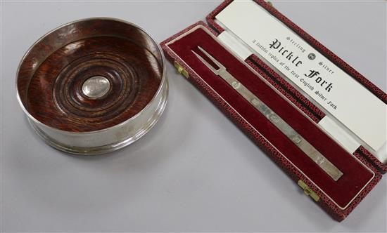 A modern silver commemorative wine coaster and a cased silver replica fork.